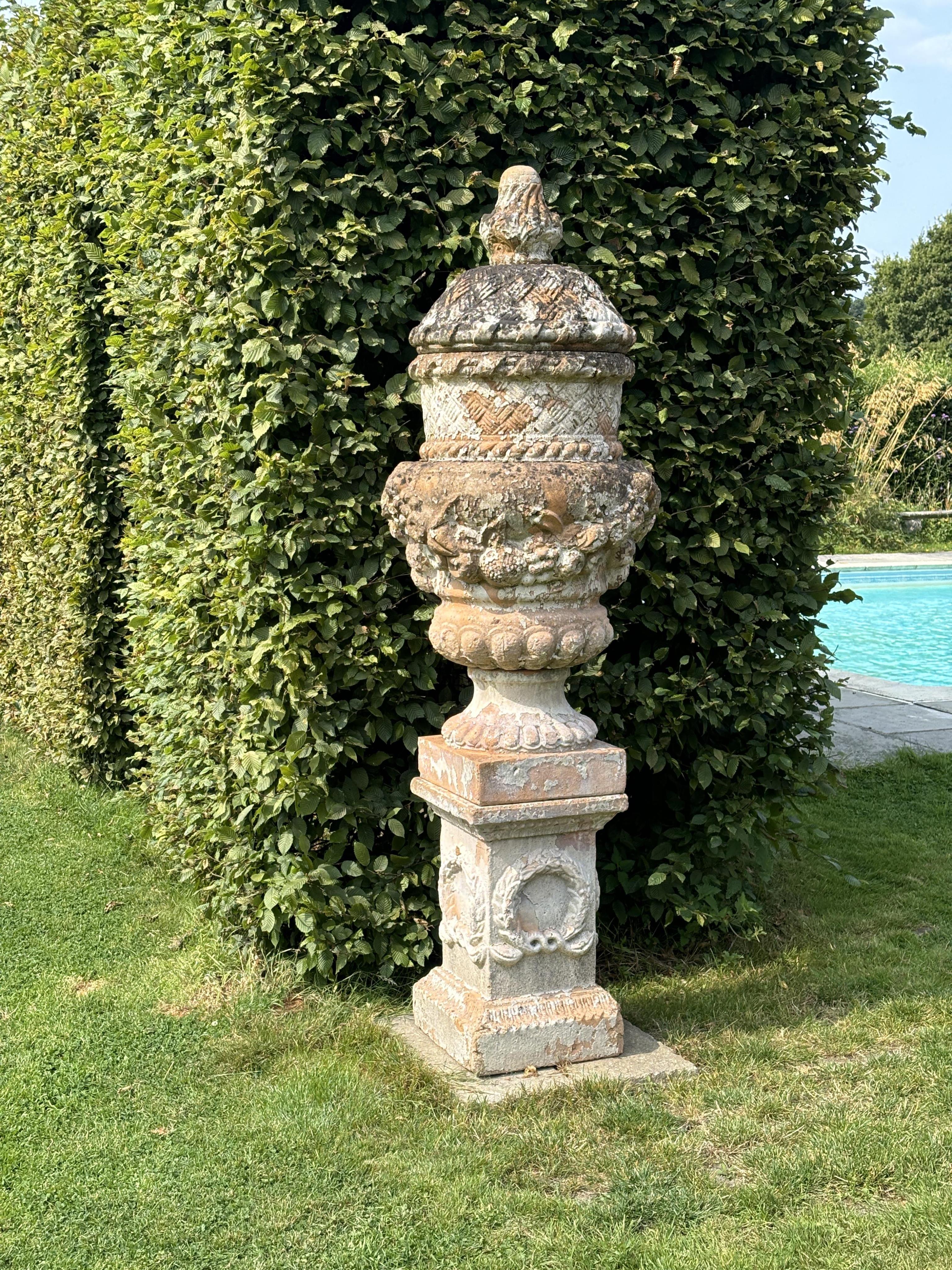 An Italian cream glazed terracotta garden urn on pedestal